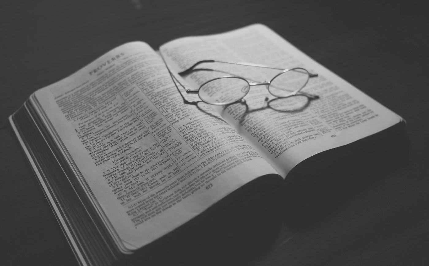 Una Biblia abierta sobre una mesa, con las páginas iluminadas