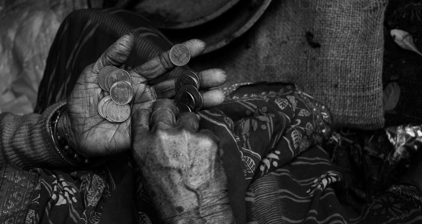 Las manos gastadas de una mujer mayor contando unas pocas monedas