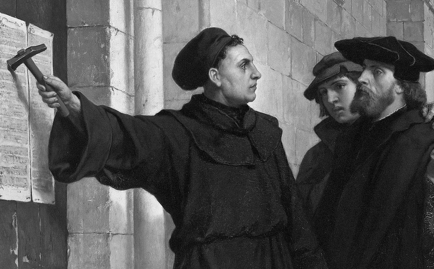 Martín Lutero, con hábito de monje, levanta un martillo frente a la puerta de una iglesia donde cuelgan sus tesis; dos hombres lo miran. Pintura de Ferdinand Pauwels, 1872