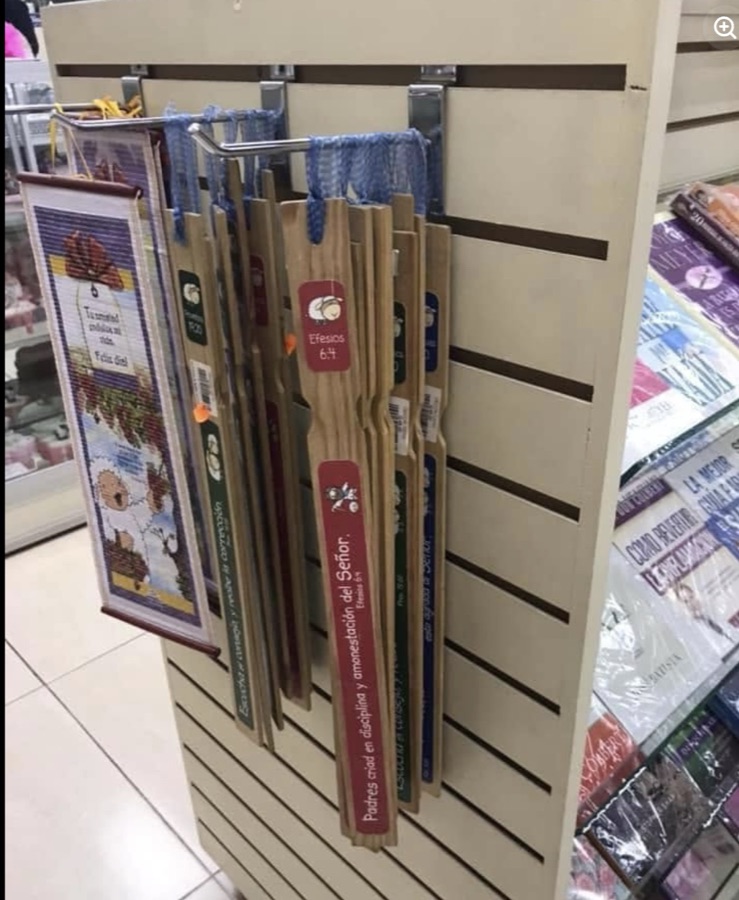 El exhibidor. Los palos cuelgan entre los tapices bordados y los libros infantiles, con su etiqueta de precio.